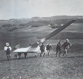 The sailplane "Grunau Baby" is hauled using muscle-power to the launch site on the crest of the hill.