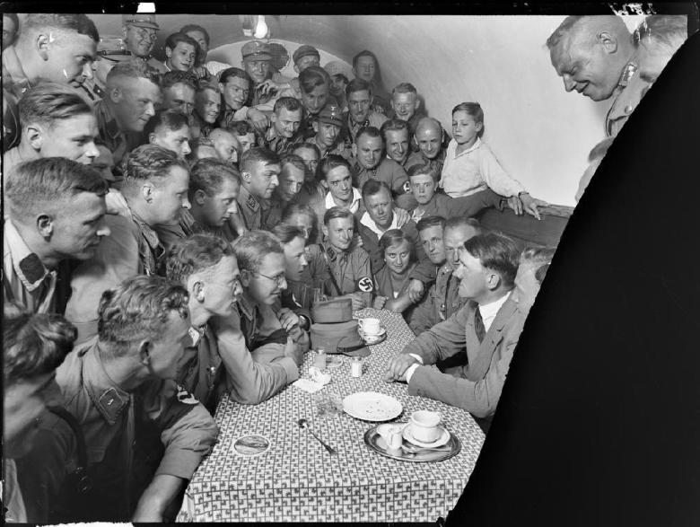 Adolph Hitler meeting with Hitler Youth members in a café.