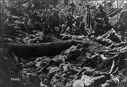 US Soldiers pose with Filipino Moro dead after the First Battle of Bud Dajo, March 7, 1906, Jolo, Philippines.