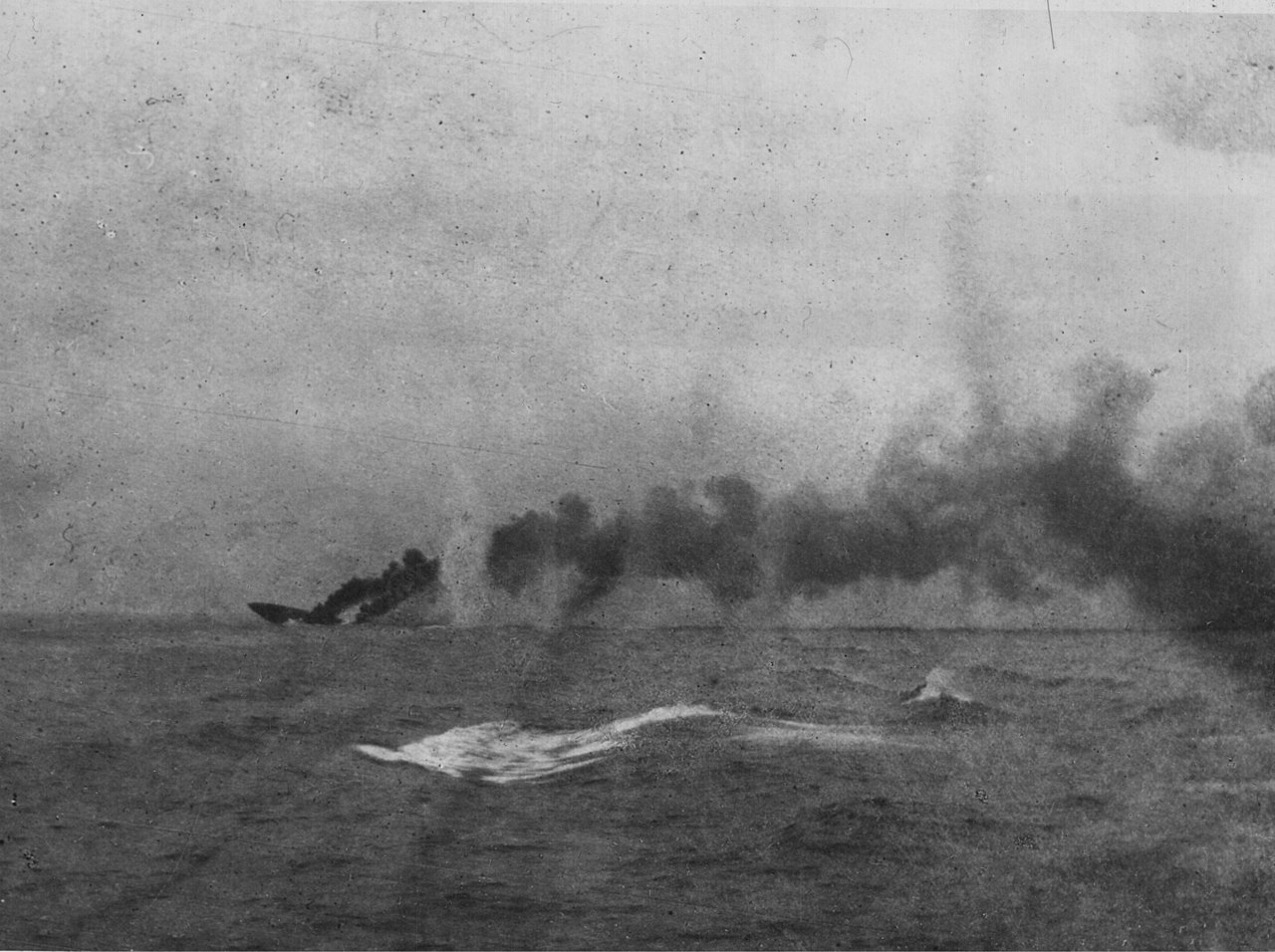 In the distance the British battlecruiser HMS Indefatigable sinking after being struck by shells from the German battlecruiser Von Der Tann