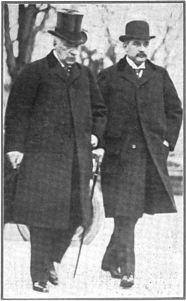 The two J. P. Morgans, father and son, stroll together dressed in identical clothing, the uniform of the wealthy banker of the day, except for their hats.