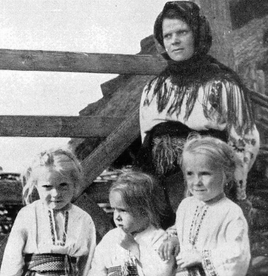 A Polish peasant woman with three little blonde-haired girls. Date unknown.