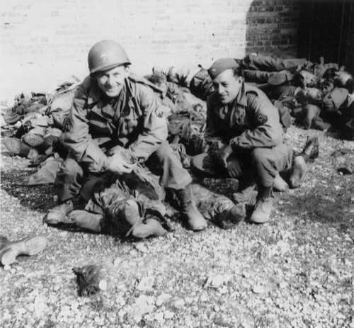 American soldiers pose with dead Germans at Dachau.