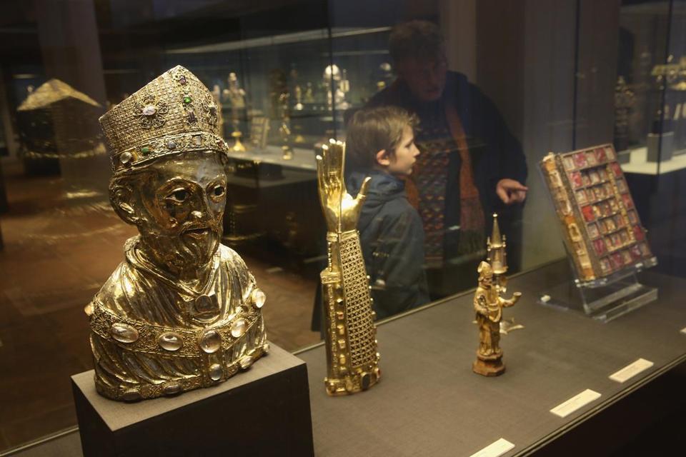 Some of the precious artworks in the Welfenschatz collection (known in English as the Guelph Treasure) on display in Berlin. Below right: a cross from the collection.