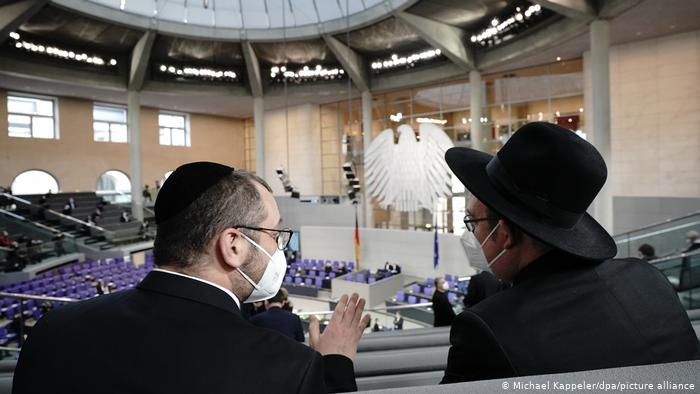 Observant Jews monitor the "Remembrance Day" service taking place in the German Bundestag