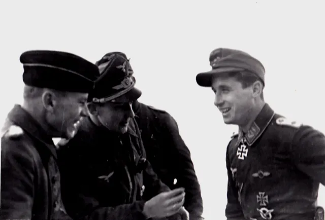 Hauptman&nbsp;Götz Baumann, far left, Poldi's Group Commander, gets into the joyous spirit of the occasion. Gen. Dessloch in center.