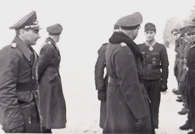 General Dessloch looks toward Poldi as the men of the squadron line up to honor their Capitan.